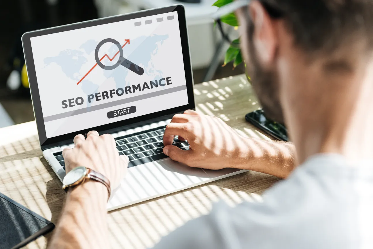 Rückansicht eines Entwicklers, der auf einem Laptop die SEO-Performance analysiert.